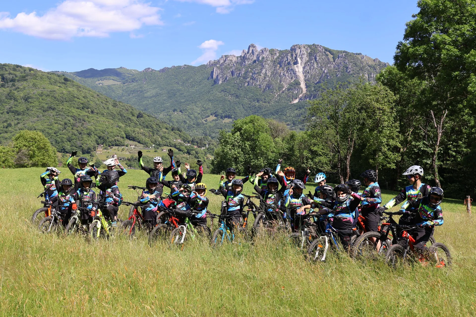 I ragazzi della WeRide Academy in bici su un prato in montagna