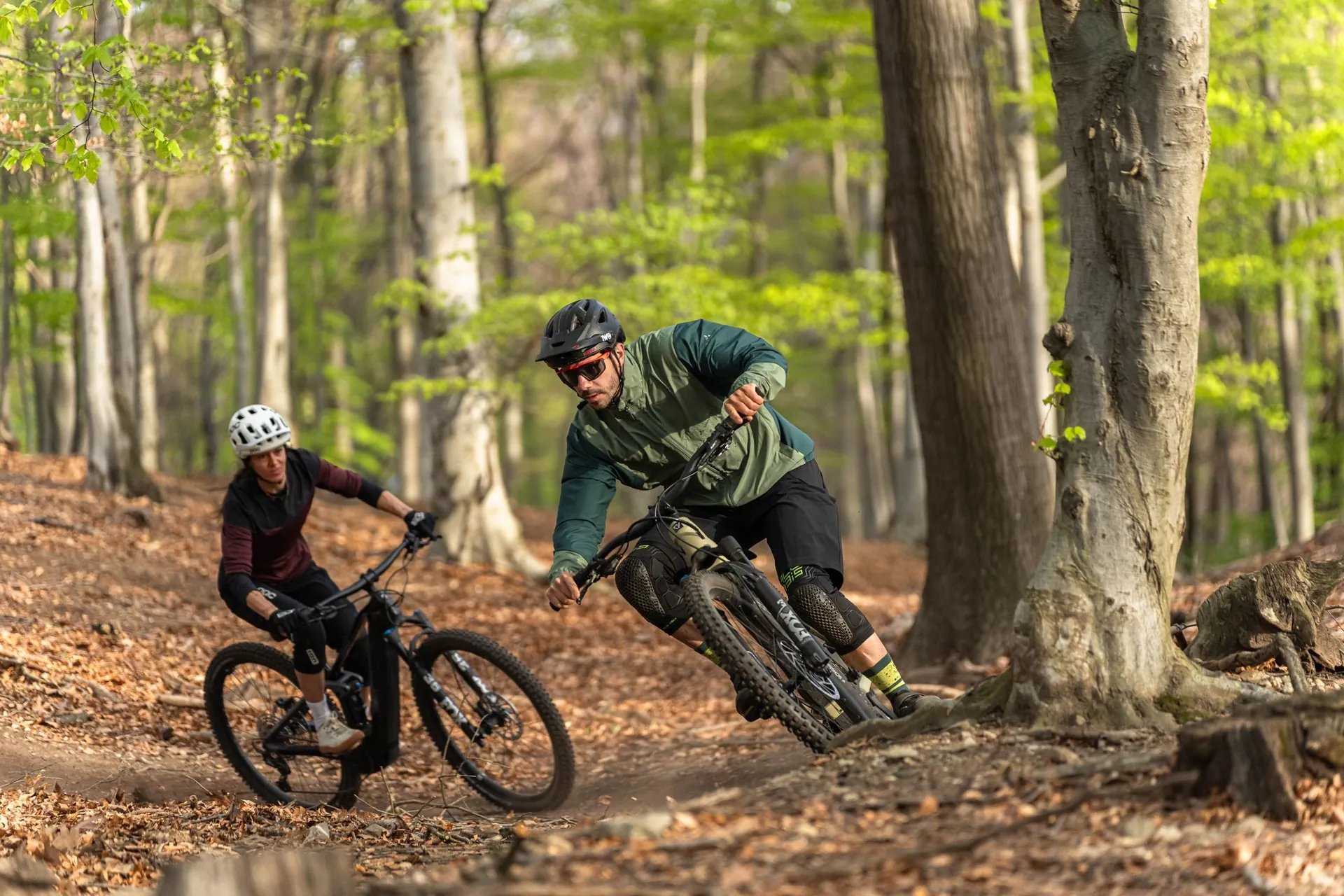 Istruttore e allieva in discesa su un trail nel bosco
