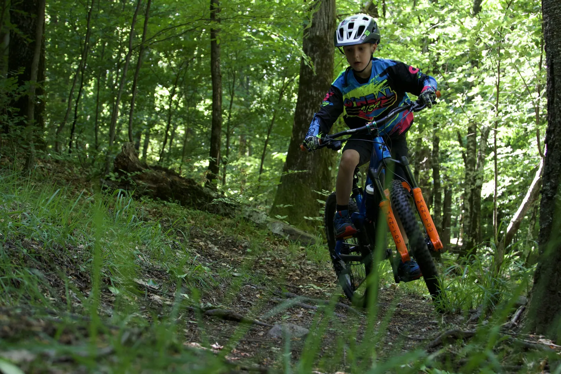 Giovane rider della WeRide Academy su un sentiero nel bosco